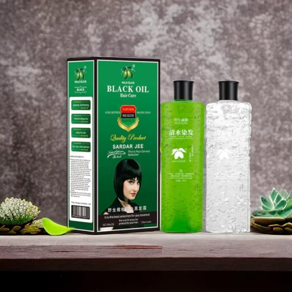 Green bottle and packaging of Sardar Jee Black Oil on a wooden surface with a gray textured background.